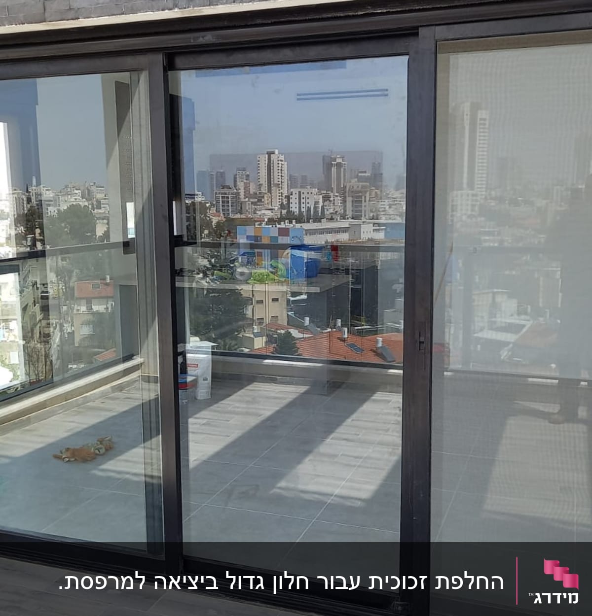 דלת זכוכית גדולה עם נוף עירוני ברקע